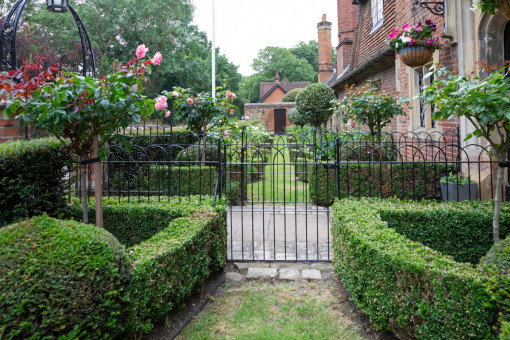 Clipped box hedges with lollipop rose bushes and bay trees