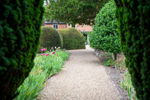 View of beautifully clipped and shaped hedges and shrubs in grounds of retirement home
