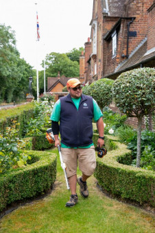 Garden maintenance operative inspecting garden