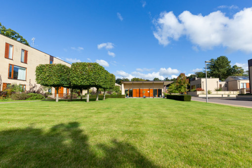 Freshly mown lawn and topiary trees in private retirement village