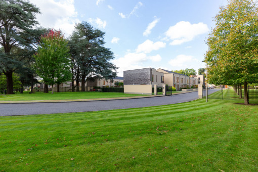 Lawn lined road leading into private properties
