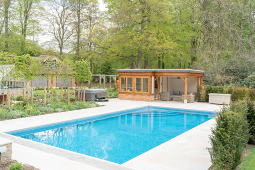 Pool area and pool house surrounded by landscaped garden