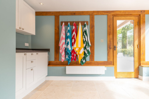 Internal shot of towels handing up in utility area in pool house