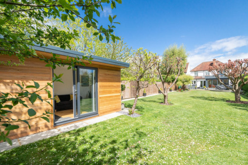 Shot of garden with large lawns and trees with garden room
