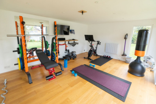 Internal shot of garden gym with weights and exercise equipment